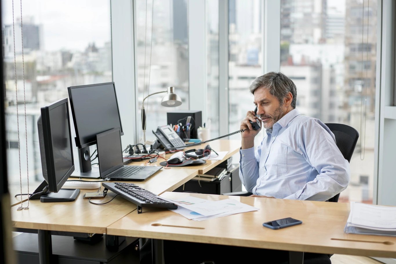 man-at-desk-talking-on-deskphone