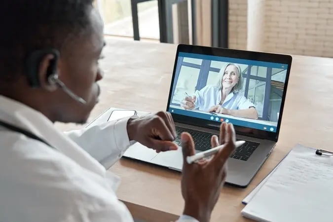 man talks to colleague remotely over video conferencing 